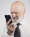 Senior man using a phone and having eyesight problems Royalty Free Stock Photo