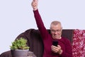 Senior man using smartphone app for creating playlist music at home. Trendy man having fun with mobile phone technology. Tech and Royalty Free Stock Photo