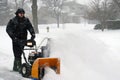 Senior man using snow blower during bad snow storm Royalty Free Stock Photo