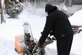 Senior man using snow blower during storm Royalty Free Stock Photo