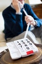 Close Up Of Senior Man Using Telephone With Oversized Keypad At