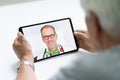 Senior Man In Videochat Or Videoconference With Doctor