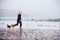 Senior Man Walking Along Winter Beach With Pet Dog Royalty Free Stock Photo