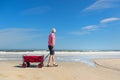 Senior man walking with cart at the beach Royalty Free Stock Photo