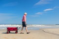 Senior man walking with cart at the beach Royalty Free Stock Photo