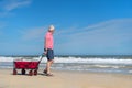 Senior man walking with cart at the beach Royalty Free Stock Photo