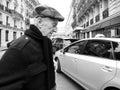 Senior man walking in front of the camera near taxi car