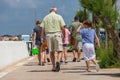 Senior man walking with young girl on pavement