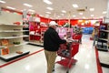 Senior man walks alone down isle of Target store past empty holiday shelves