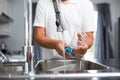 Senior man washing dishes in his  kitchen Royalty Free Stock Photo