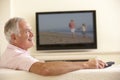 Senior Man Watching Widescreen TV At Home Royalty Free Stock Photo