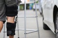 Senior man wear knee support brace on leg standing at the car parking lot, Medical and healthcare concept Royalty Free Stock Photo