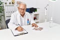 Senior man wearing doctor uniform doing rorscharch test at clinic Royalty Free Stock Photo