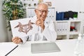 Senior man wearing doctor uniform doing rorscharch test at clinic Royalty Free Stock Photo