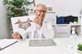 Senior man wearing doctor uniform doing rorscharch test at clinic Royalty Free Stock Photo