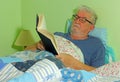 Senior man reading in bed.