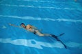 Senior man wearing goggles, cap and flippers swimming in indoor pool Royalty Free Stock Photo