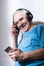 Senior man wearing headphones using smartphone Royalty Free Stock Photo