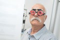senior man wearing opticians test glasses with interchangeable lenses