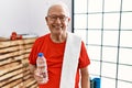 Senior man wearing sportswear and towel at the gym with a happy and cool smile on face Royalty Free Stock Photo