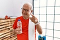 Senior man wearing sportswear and towel at the gym pointing fingers to camera with happy and funny face Royalty Free Stock Photo