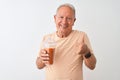 Senior man wearing striped t-shirt drinking tomato smoothie over isolated white background happy with big smile doing ok sign, Royalty Free Stock Photo