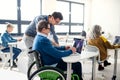 Senior man in wheelchair attending computer and technology education class. Royalty Free Stock Photo