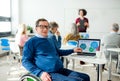 Senior man in wheelchair attending computer and technology education class. Royalty Free Stock Photo