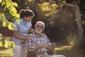 Senior man in wheelchair and nurse looking at tablet Royalty Free Stock Photo