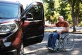 Senior man in wheelchair opening door of his van Royalty Free Stock Photo