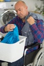 Senior man in wheelchair sorting laundry Royalty Free Stock Photo