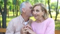 Senior man whispering jokes, flirting with woman, mature love, old age happiness Royalty Free Stock Photo