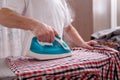 Senior man at home ironing his clothes