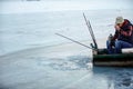 Senior man in winter fishing drink tea on frozen lake Royalty Free Stock Photo