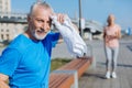 Senior man wiping sweat from the forehead with towel