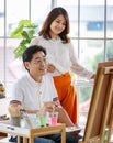 Senior man and woman couple, husband and wife, painting image together in home gallery with warm and happy circumstance. Idea for