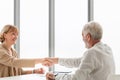 Senior man and woman handshake, Middle-aged lady shake hands with senior man, Smiling old mature saleswoman handshake client Royalty Free Stock Photo