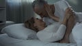 Senior man and woman lying in bed and nuzzling, happily married, tenderness