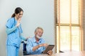 Senior man and woman making online call using tablet. Nurse Helps Senior man Video Chat On Tablet In Nursing Home Or At Home Royalty Free Stock Photo