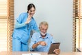 Senior man and woman making online call using tablet. Nurse Helps Senior man Video Chat On Tablet In Nursing Home Or At Home Royalty Free Stock Photo