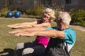 Senior man and senior woman performing stretching exercise in the park Royalty Free Stock Photo