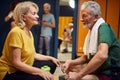 Senior man and woman in sportswear sitting in dressing room talking, cheering each other up for workout Royalty Free Stock Photo