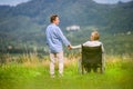 Senior man with woman in wheelchair, green autumn nature Royalty Free Stock Photo