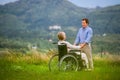 Senior man with woman in wheelchair, green autumn nature Royalty Free Stock Photo