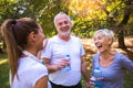 Senior man and woman and young female instructor workout on fresh air