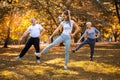 Senior man and woman and young female instructor workout on fresh air.