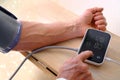 Senior man working with blood pressure machine at home to check his health, self-management, senior health assessment,