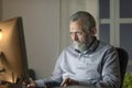 Senior man working with his computer at night Royalty Free Stock Photo