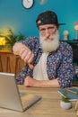Senior man working on laptop computer at home office showing thumbs down sign dislike disapproval Royalty Free Stock Photo