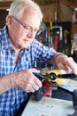 Senior Man Working On Model Radio Controlled Aieroplane In Shed At Home
